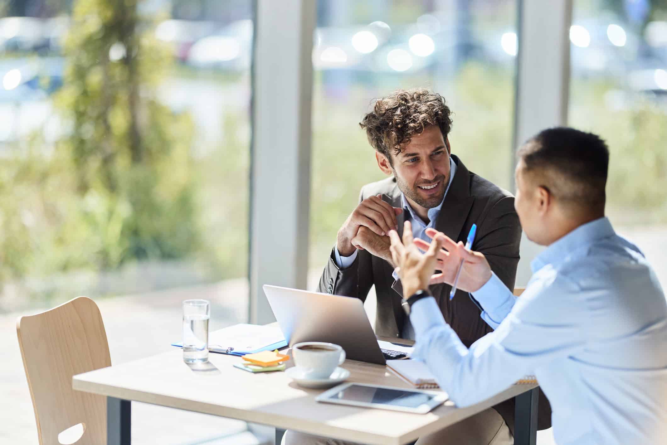 2 working professional immigrants discussing on their evaluation report