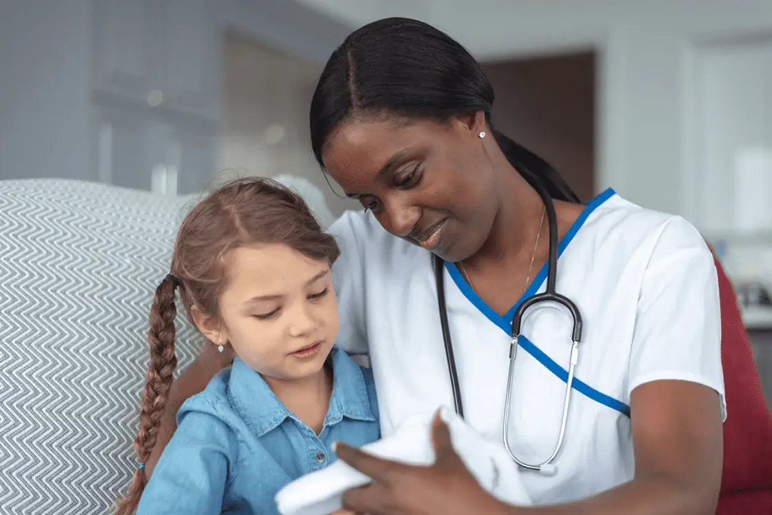 Nurse holding baby with sibling