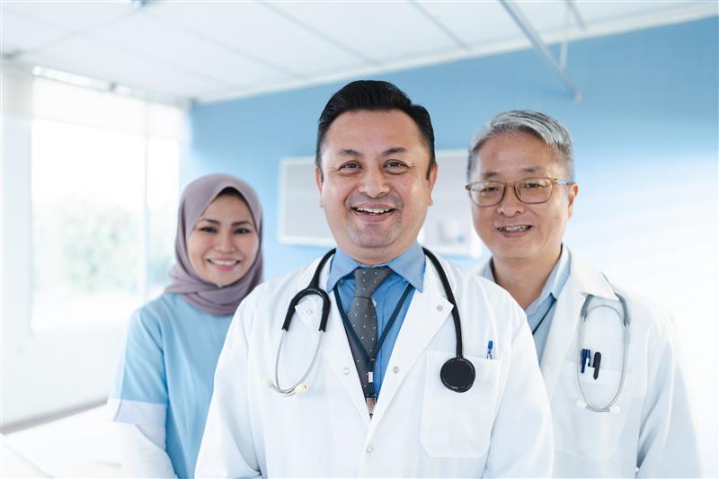 Three internationally trained medical professionals smile at the camera.