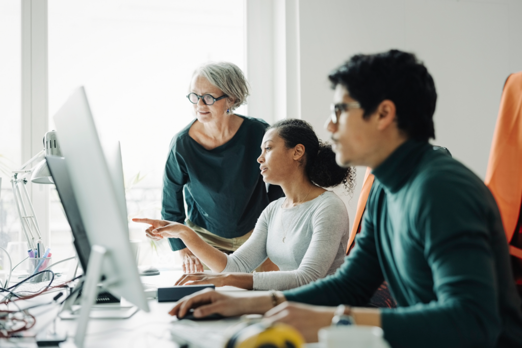 A group of professionals at desks work on computers.