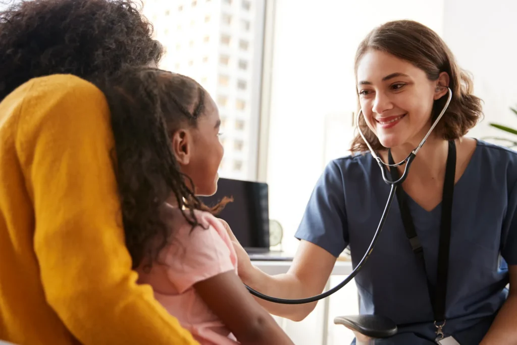 A young immigrant doctor listens to a child's breathing with a stethoscope