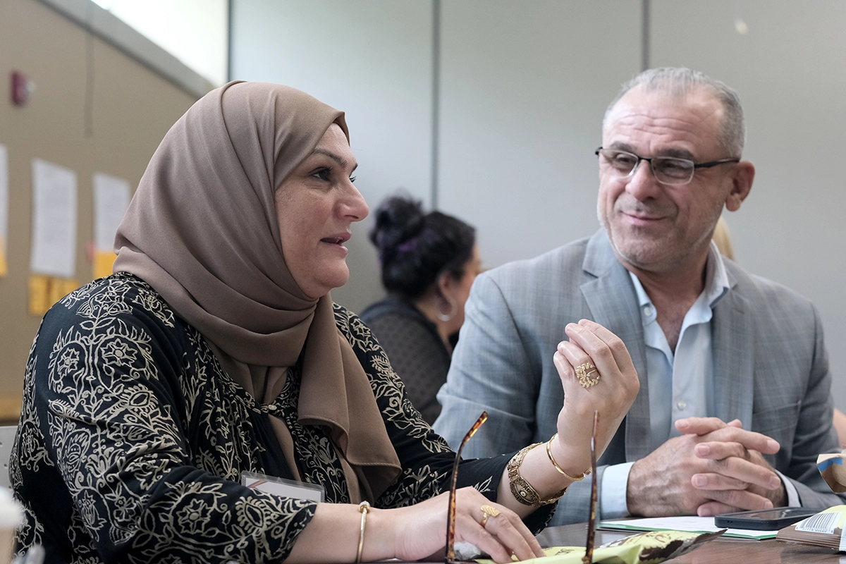 An immigrant woman in hijab speaks at a conference