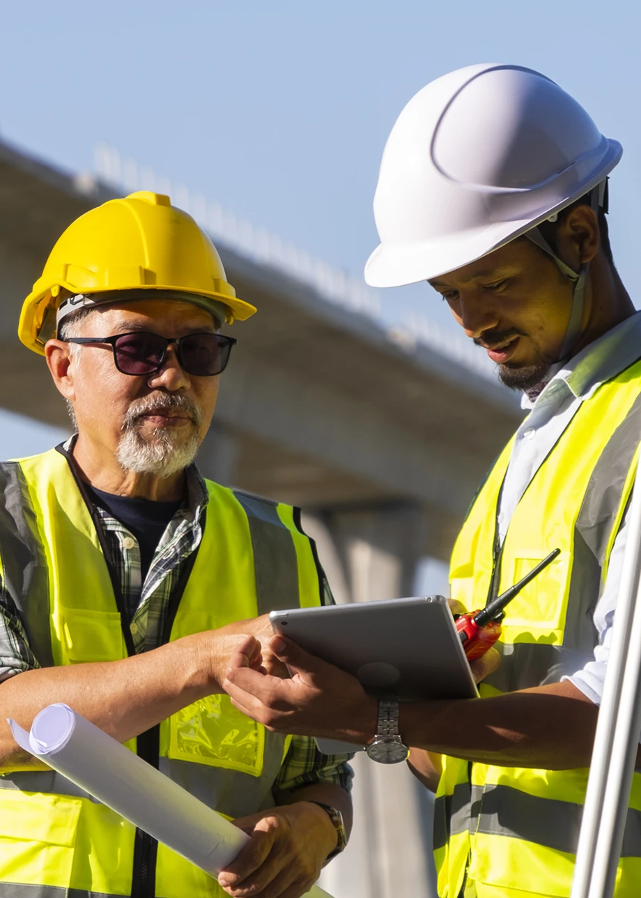 Two construction workers consult their plans.